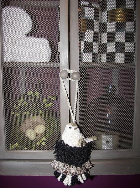 Black and white handmade tassel with bird figurine. 
