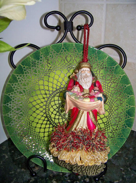 Festive Christmas tassel with a Santa Clause figurine in colors red, gold and green. 